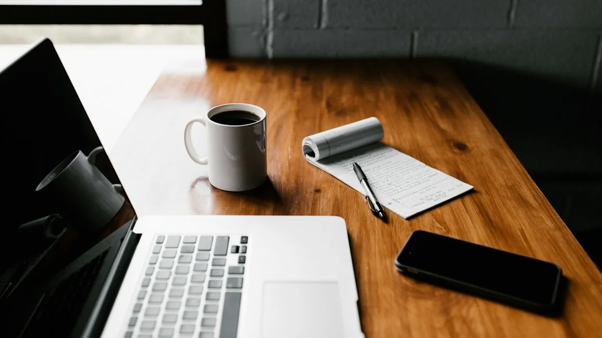 Laptop dan secangkir kopi di atas meja kayu